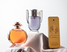 Three luxury fragrances displayed on a silk sheet