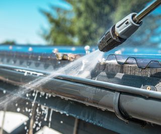 An extreme close up of pressure washing a gutter