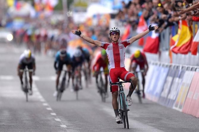 Michal Kwiatkowski (Poland) celebrates while the small group behind him sprints for the silver and bronze