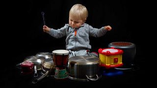 A baby playing on pots and pans