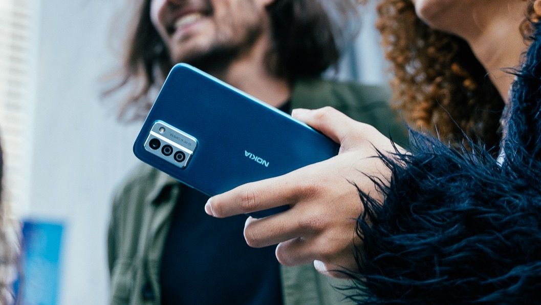 Nokia g32 in blue being held by woman with red hair