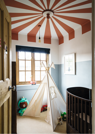 Ένα παιδικό δωμάτιο με κόκκινη και άσπρη βαμμένη οροφή σαν ομπρέλα