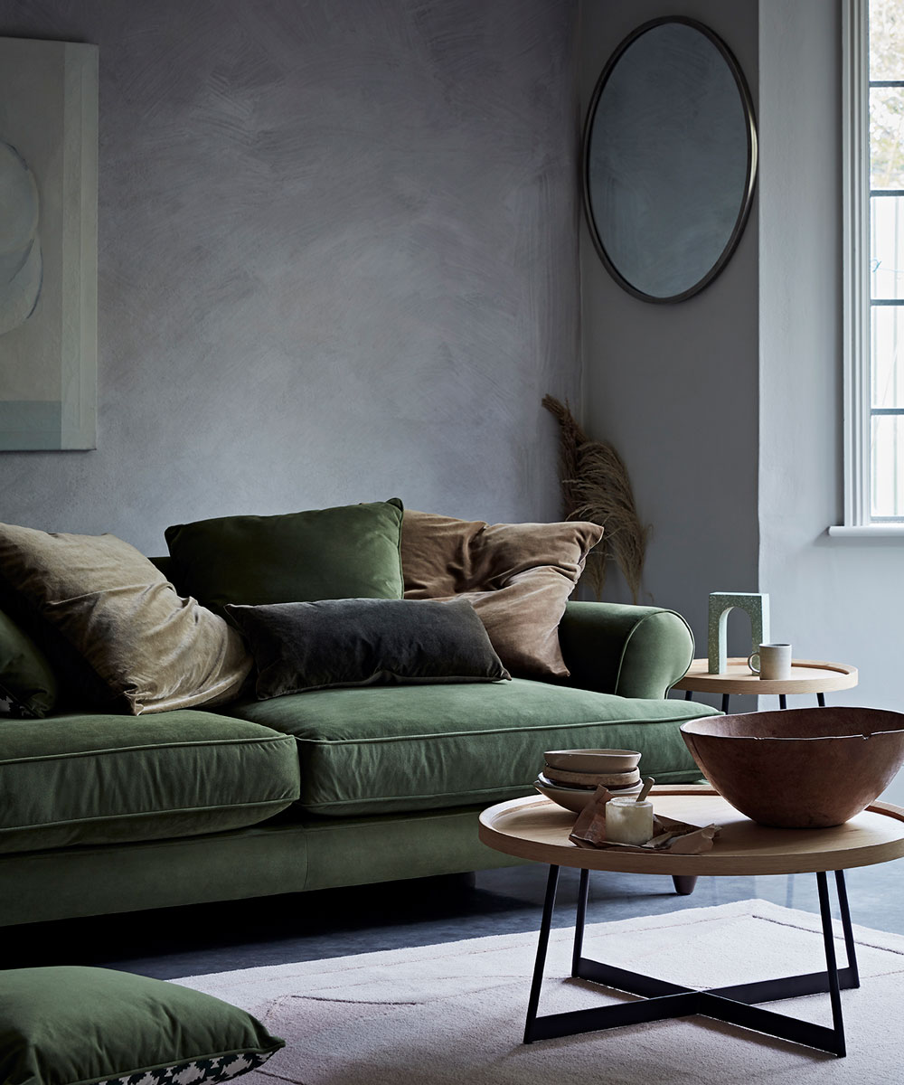 living room with green sofa and wooden round table