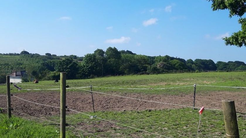 A field with a small fence with an electric fence