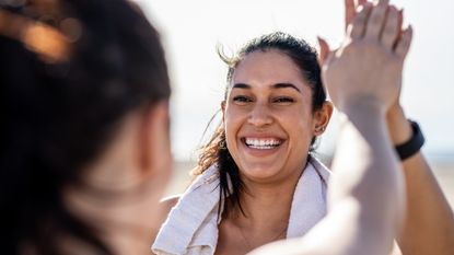 Women high five in workout clothes