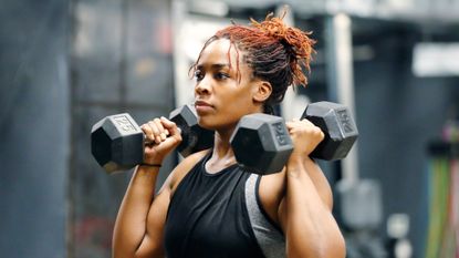 Woman using dumbbells to perform a shoulder press