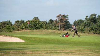 A general view of a greenkeeper mowing a green
