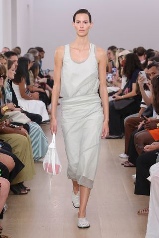 a Proenza Schouler model walks the spring/summer 2024 runway in mesh leather glove flats