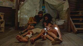 L-R: Adam (Zain Al Rafeea), Nabil (Ziad Bakri), Yasmine (Nadine Labaki) and Jana (Riman Al Rafeea) huddled together in Netflix's "The Sand Castle".