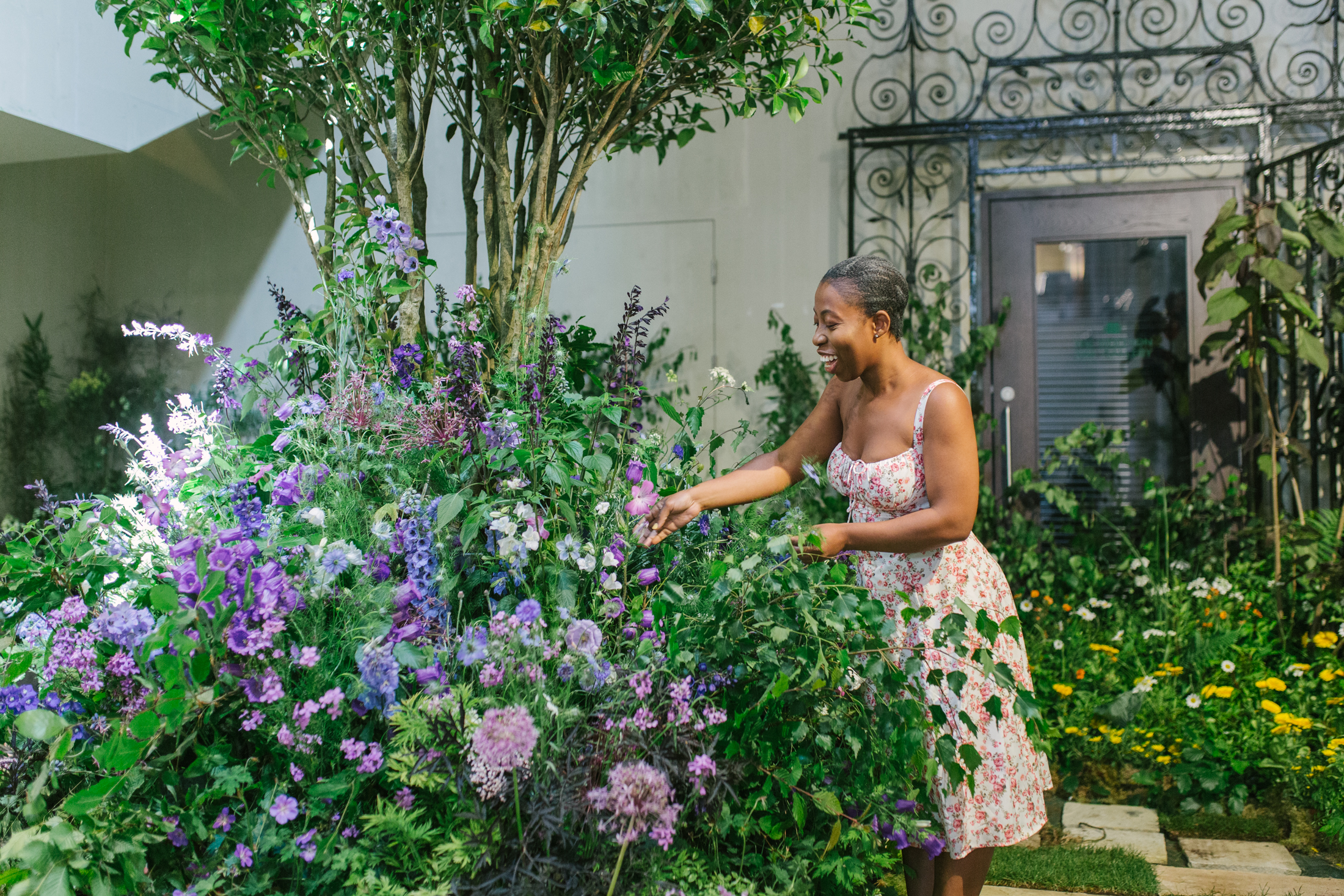A woman examines a large floral arrangement