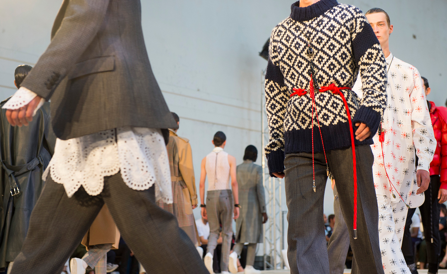 Male models on a runway wearing clothes from the Alexander McQueen S/S 2018 collection