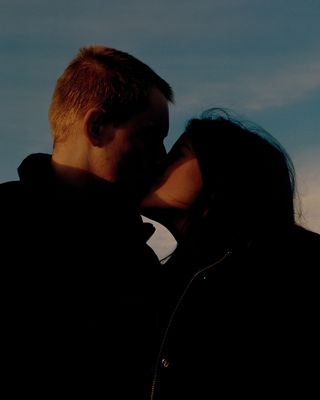 Photograph of a man and a woman in shadow, kissing