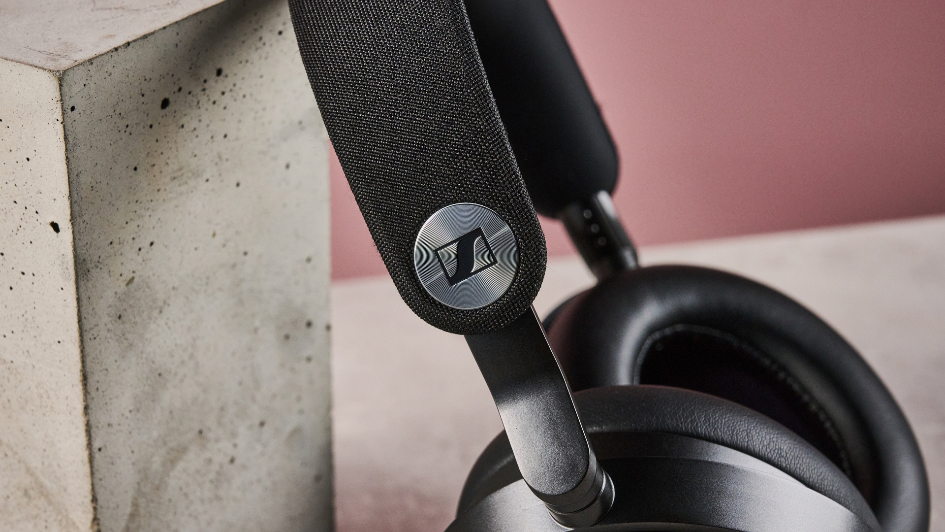 A closeup of the round Sennheiser logo on the headband of the Sennheiser Momentum 5.