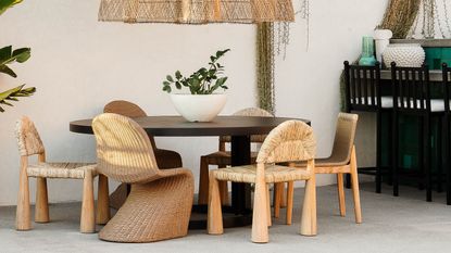 A set of wicker chairs around an outdoor dining table