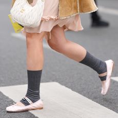 A woman wearing Miu Miu pink satin flats 