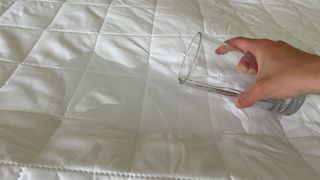 OTTY Waterproof Mattress Protector with water poured over it