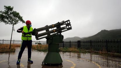 A worker fires a cloud-seeding rocket