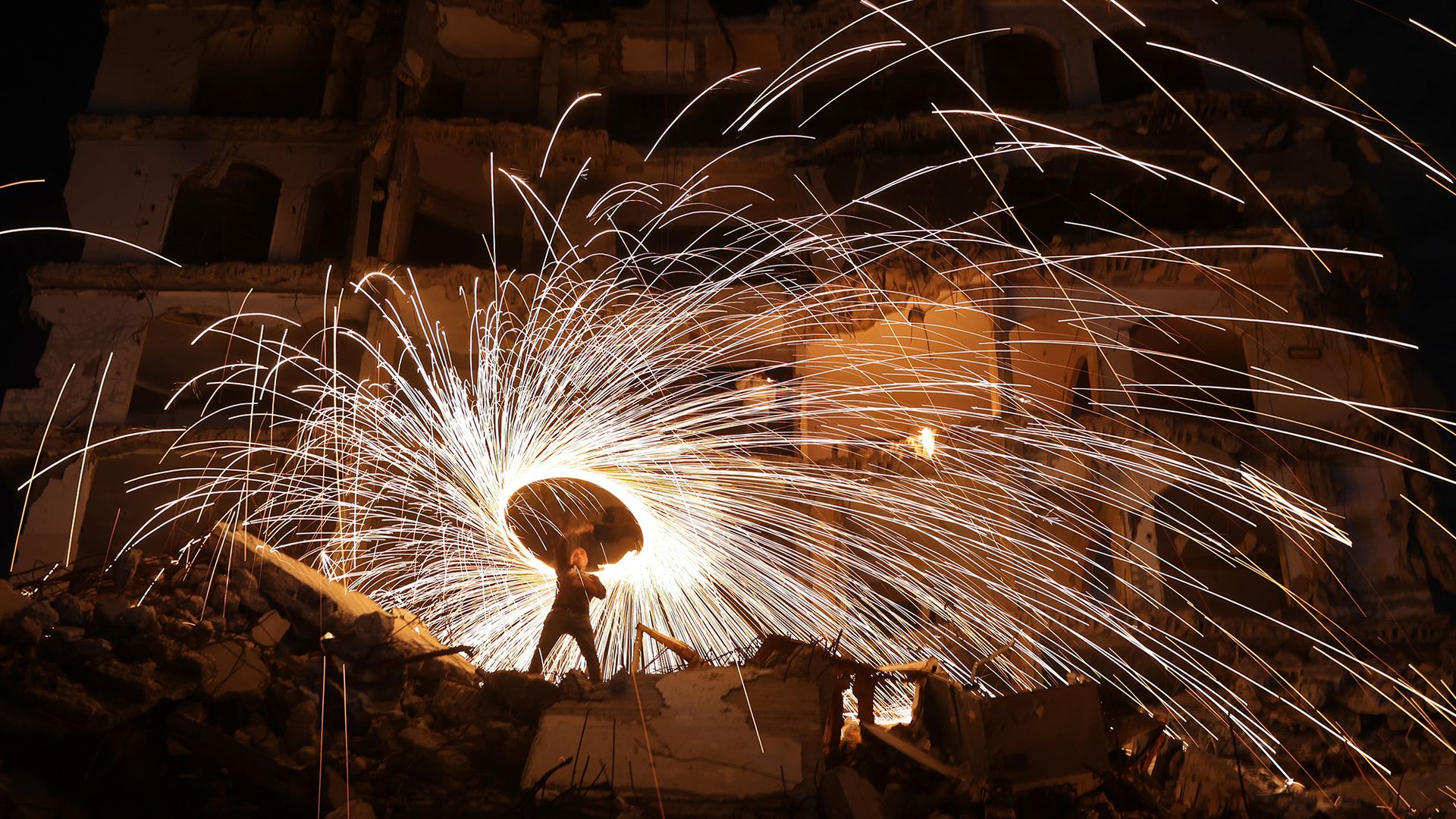 
                                A displaced Palestinian plays with fireworks outside a building damaged by Israeli strikes at the Jabalia refugee camp, Palestine
                            