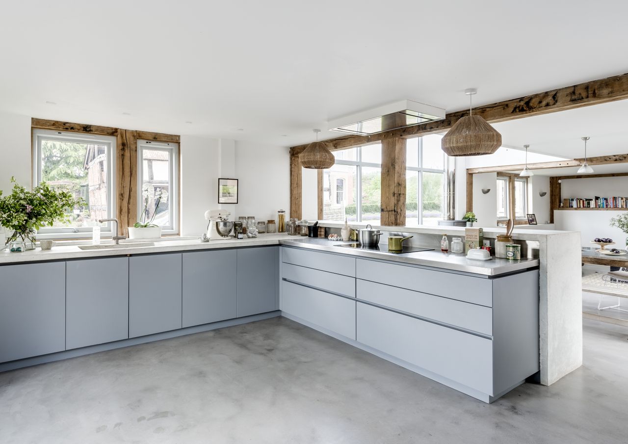light blue grey kitchen units on top of polished concrete floor