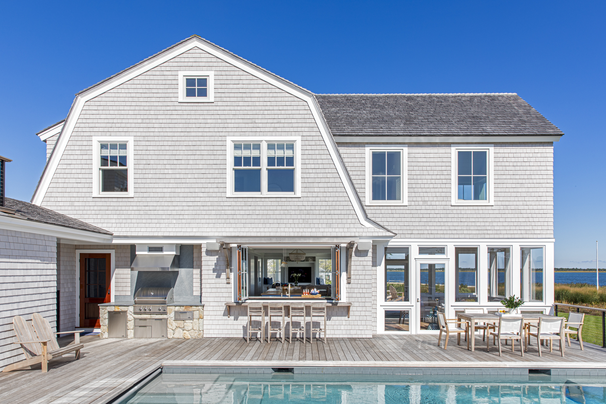 modern cape cod house exterior with swimming pool