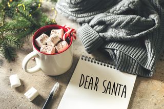 Letter to santa claus and mug with chocolate with marshmallow on desk
