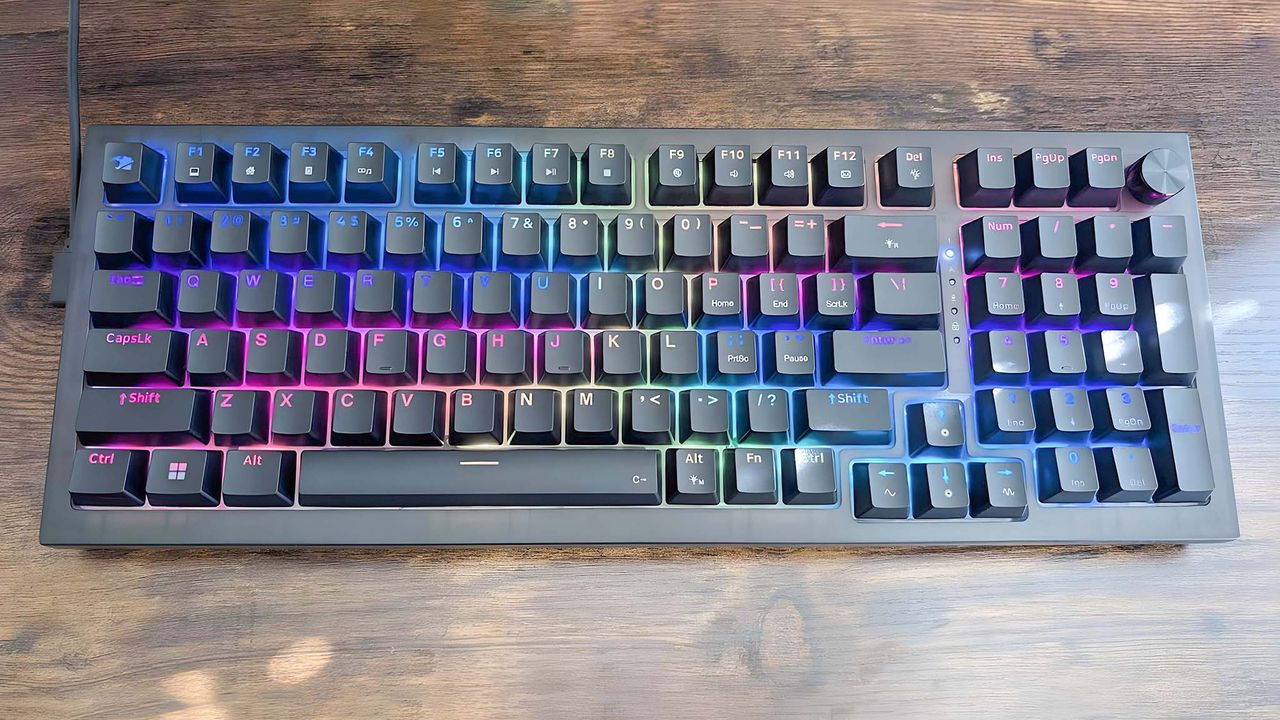 A top-down view of the iBuyPower MK9 Pro RGB Mechanical Keyboard with rainbow RGB turned on at a lower brightness.