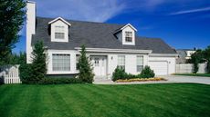 A Cape Cod house with a green lawn