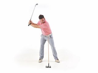 Josh Mayo demonstrating a sway in the golf swing using an alignment stick for reference