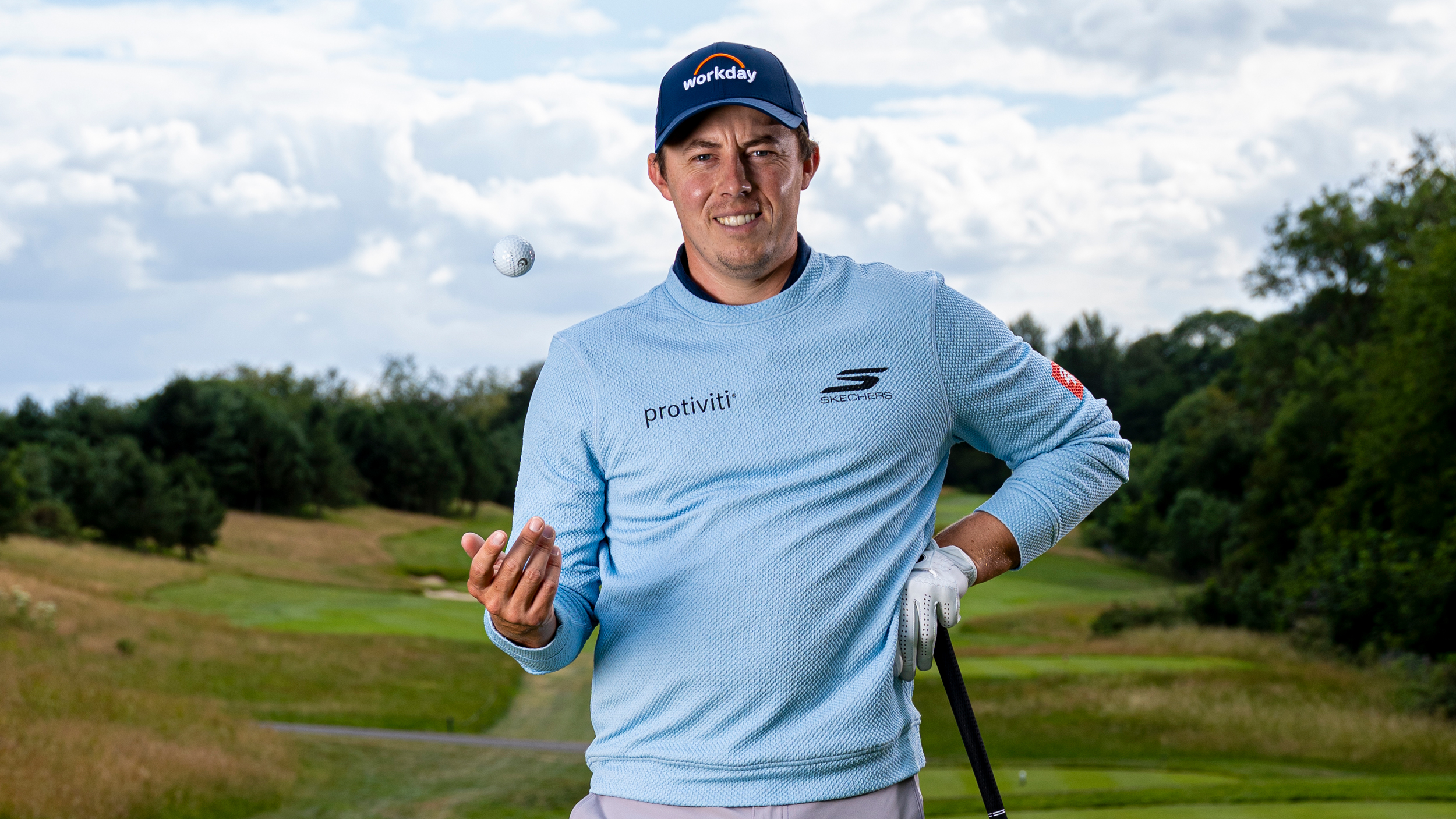 Matt Fitzpatrick looking down the camera while tossing a ball in the air