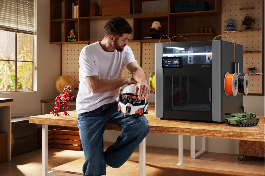 LightMake printer on table with man holding 3-D printed helmet on lap