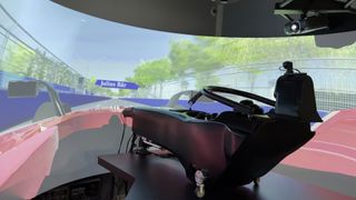 A person sits in a racecar simulator run on Scalable Display Technology software. 