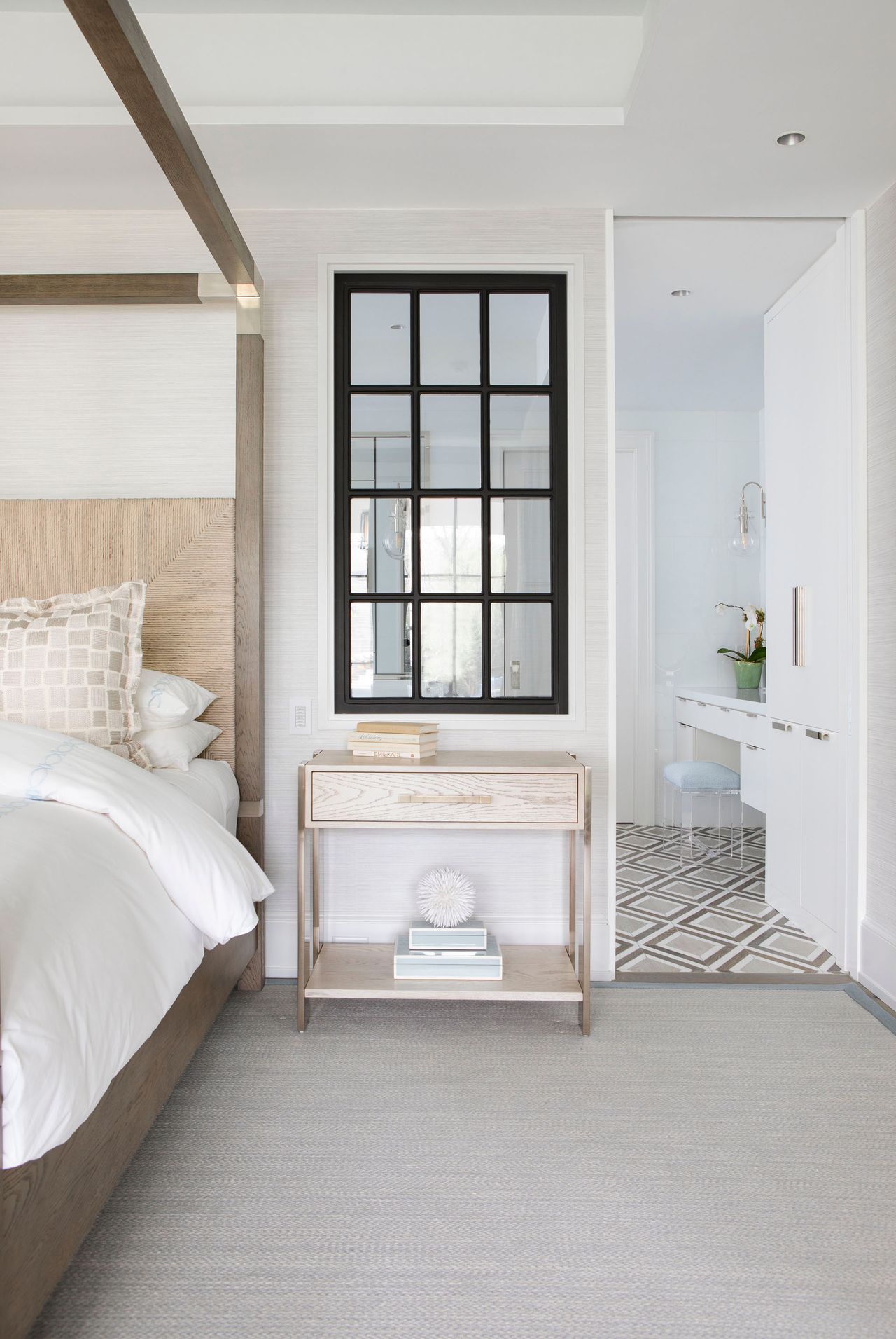 Mirror with window fame design, light wood bedside table, fourposter bed and wallpaper