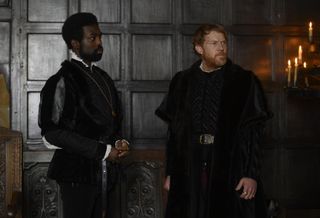 George (Paapa Essiedu) stands inside the Palace alongside the Duke of Norfolk (Kris Hitchen)