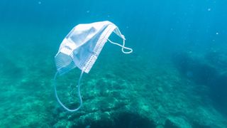 surgical mask floating in ocean water