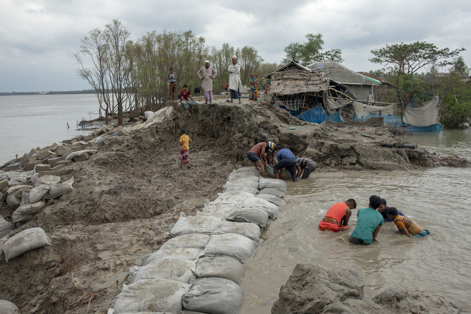 Village people try to repair the broken dam after the landfall of cyclone Amphan in Satkhira, a town on the Bay of Bengal, in Spring 2020.