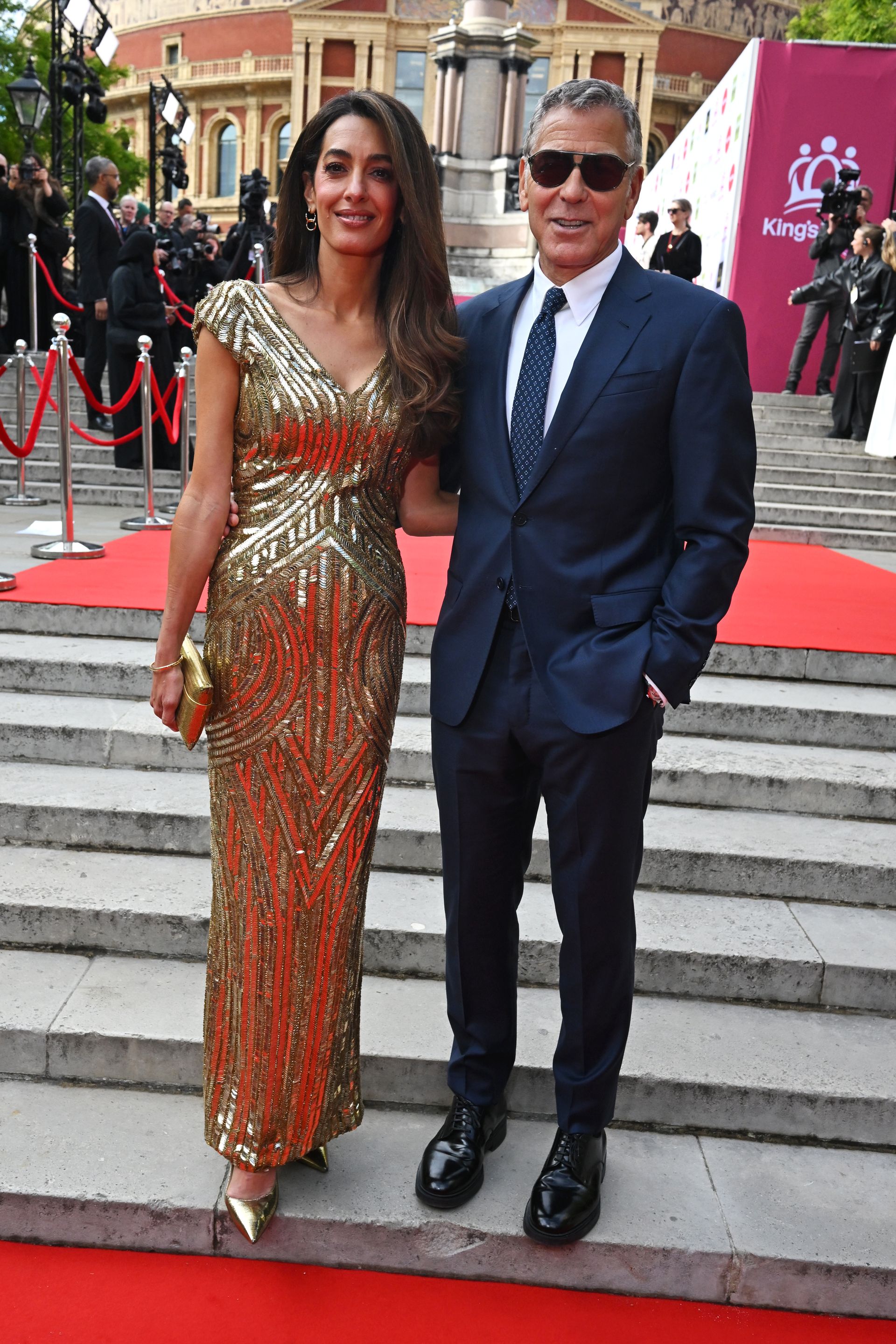 Amal Clooney wears a gold floor-length sequin gown at the King's Trust event red carpet