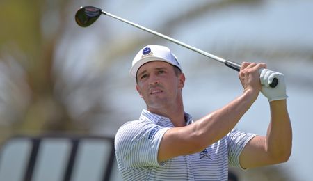 Bryson DeChambeau hits and watches his tee shot