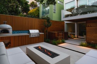 a small garden with an outdoor kitchen and hottub