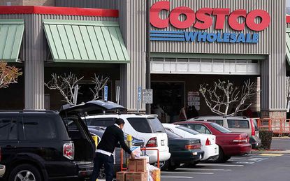 Image of someone putting groceries into their car in front of a Costco Wholesale store.