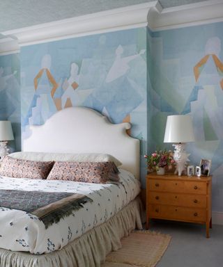 Blue bedroom with soft blue wallpaper and wooden bedside tables