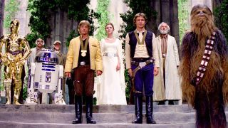 Still from a Star Wars movie. Here we see Luke Skywalker and Han Solo receiving a gold medal. Standing on the stage in the background is Chewbacca, Ben Kenobi, Princess Leia, R2-D2 and C-3PO.