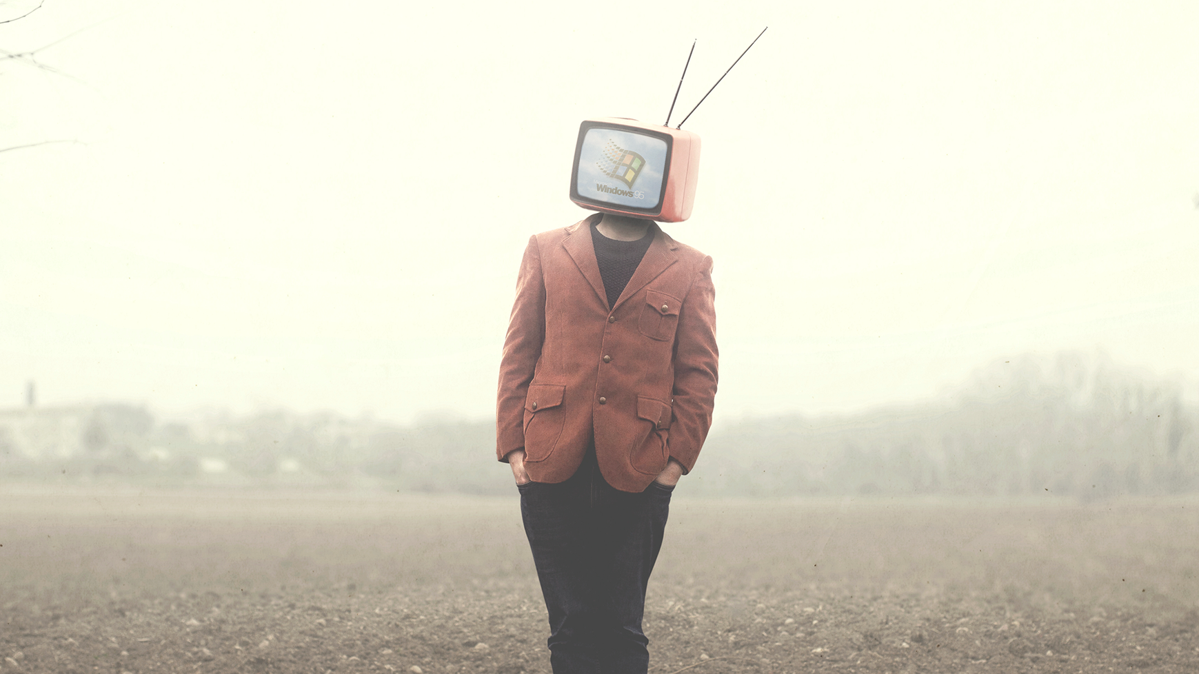 man walking on field with television on his head