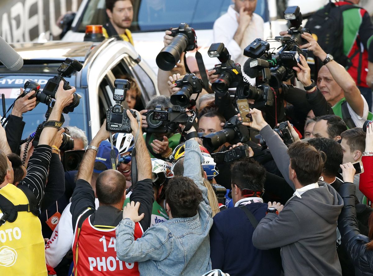 Photographers try to get a picture of the new champion