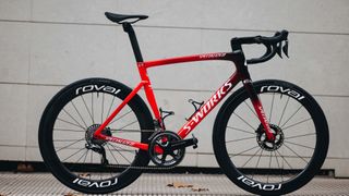 Specialized Tarmac SL7 in red and black in front of a pale wall