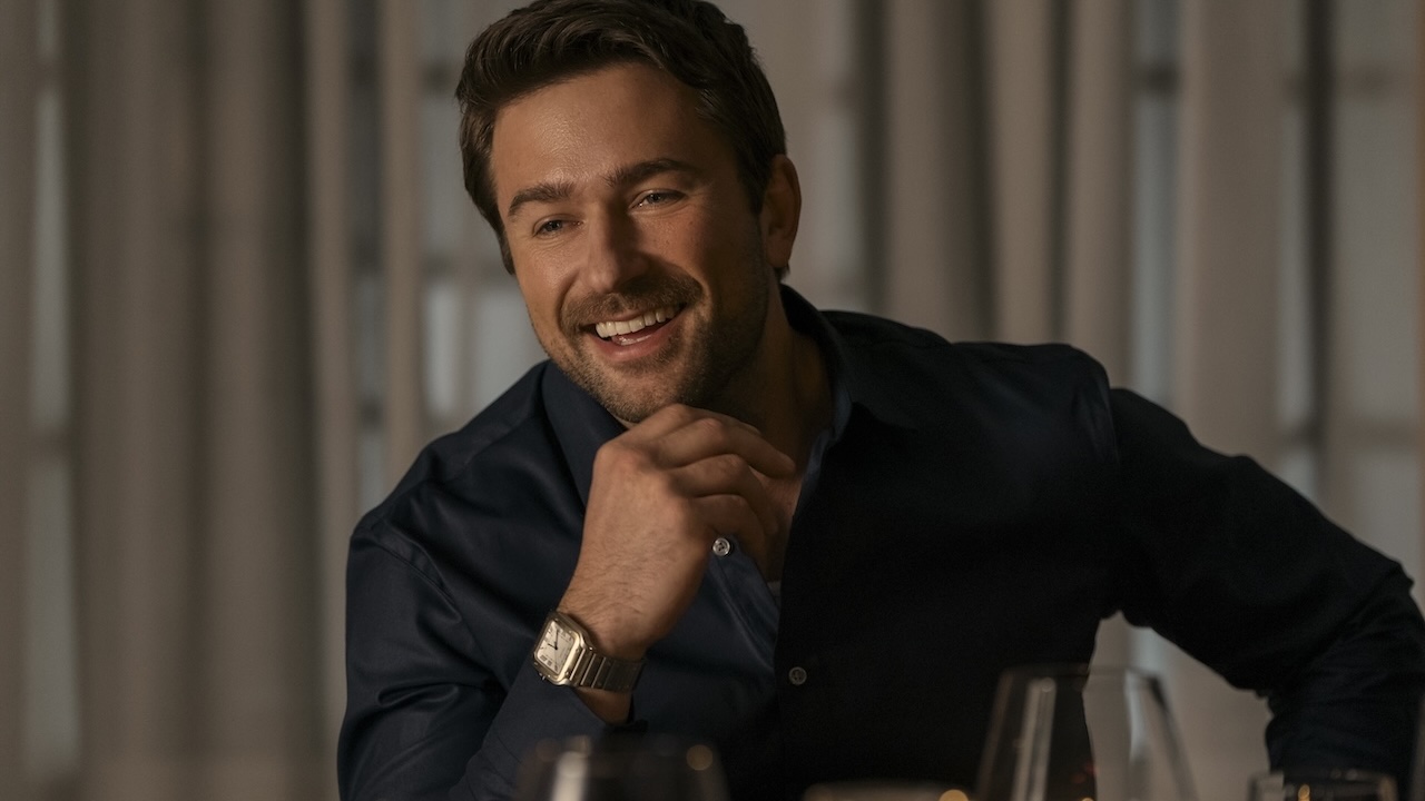 Brandon Sklenar smiling at a table in The Housemaid