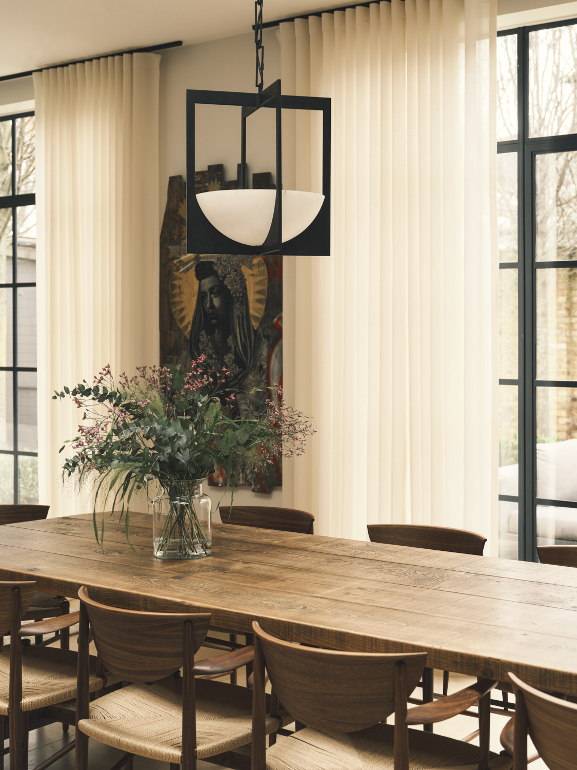 Dedar wool sheer curtains in a neutral dining space with a wooden table and chairs and black metal pendant light