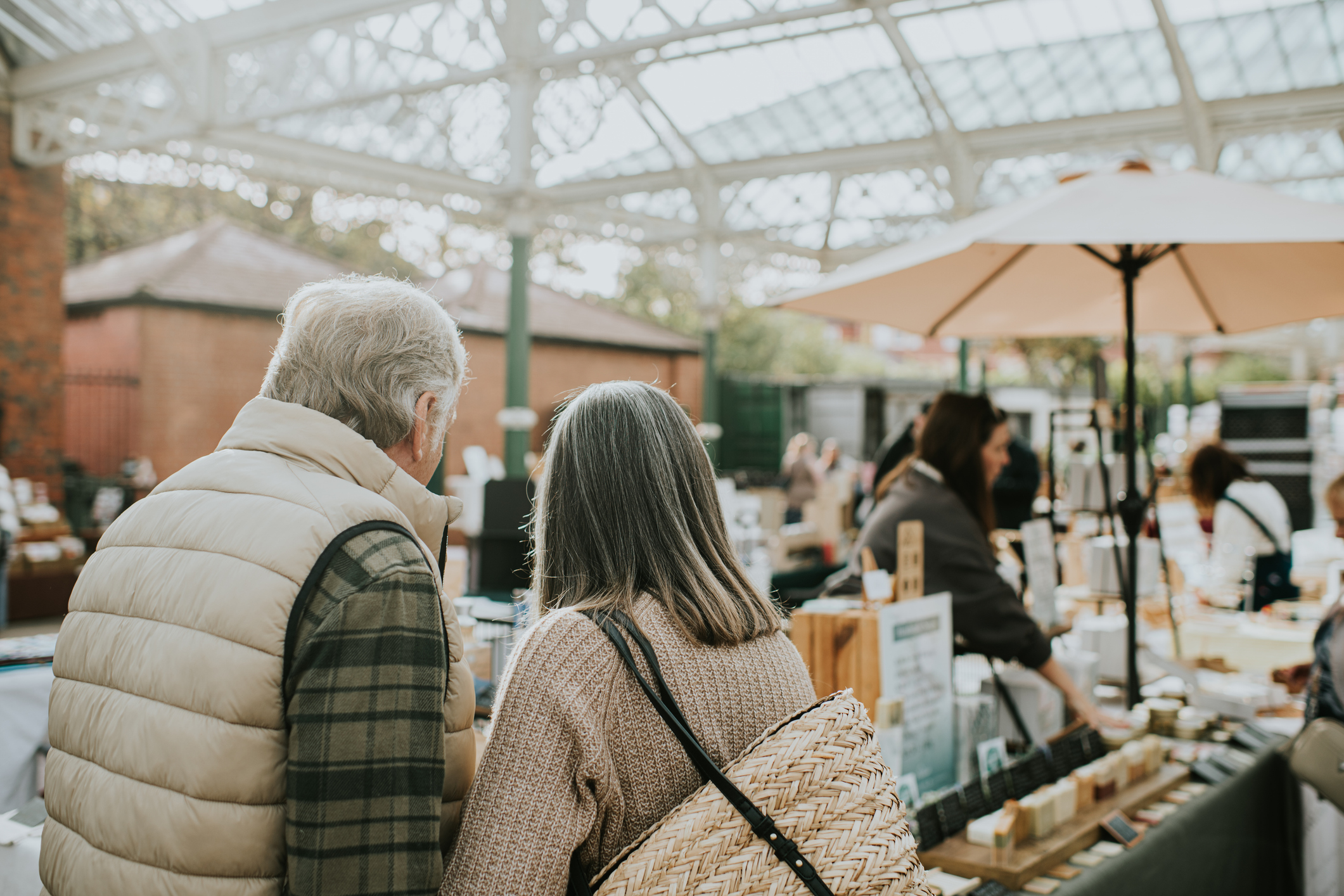 married couple enjoy browsing a stall in an indoor market