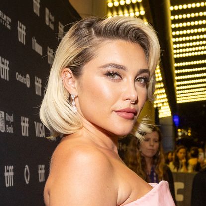 Florence Pugh has a blonde bob with darker roots, and wears a pink strapless dress on the red carpet