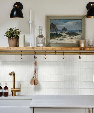 white tiles in kitchen with open shelves and gold tap