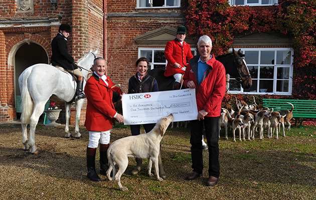 One of the Dunston Harriers gets in on the act during the presentation of a cheque by hunt chairman Brian King and Georgie Mann to Patrick Peel of the air ambulance